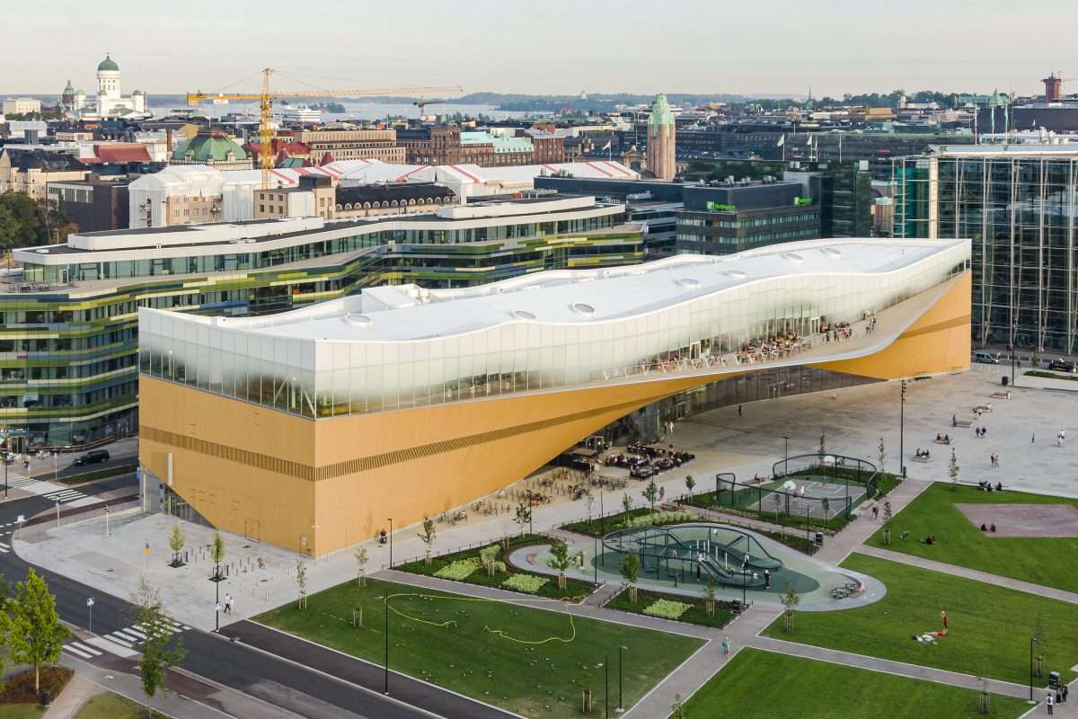 Exterior view of Central Library Oodi in Helsinki, showcasing its futuristic design and white wave-like structure.