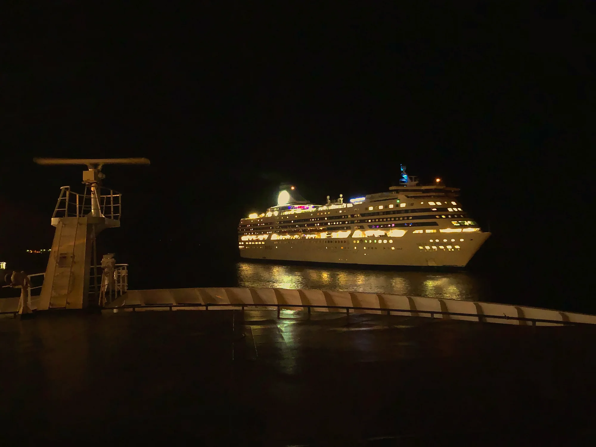 A brightly lit cruise ship passing at night on the Baltic Sea, seen from the deck of the Stockholm–Helsinki overnight ferry
