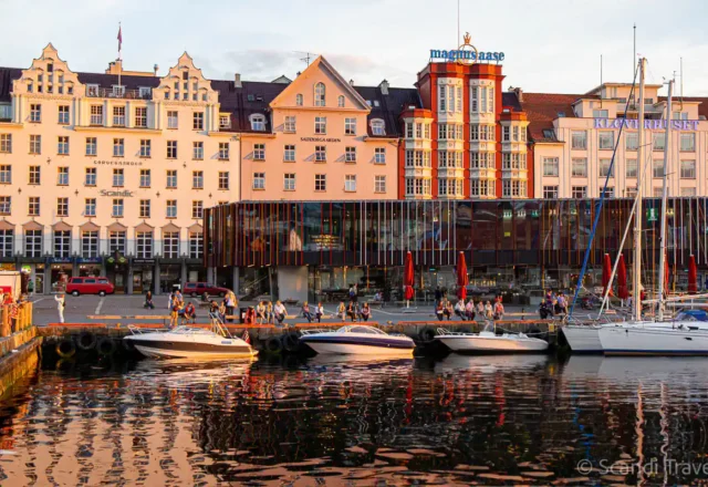 Colorful buildings and boats at the Bergen waterfront during sunset on a Scandinavian tour