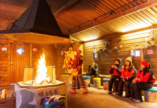 Guests enjoying traditional Sámi drumming and storytelling around an indoor fire during the Lapland Arctic Adventure tour
