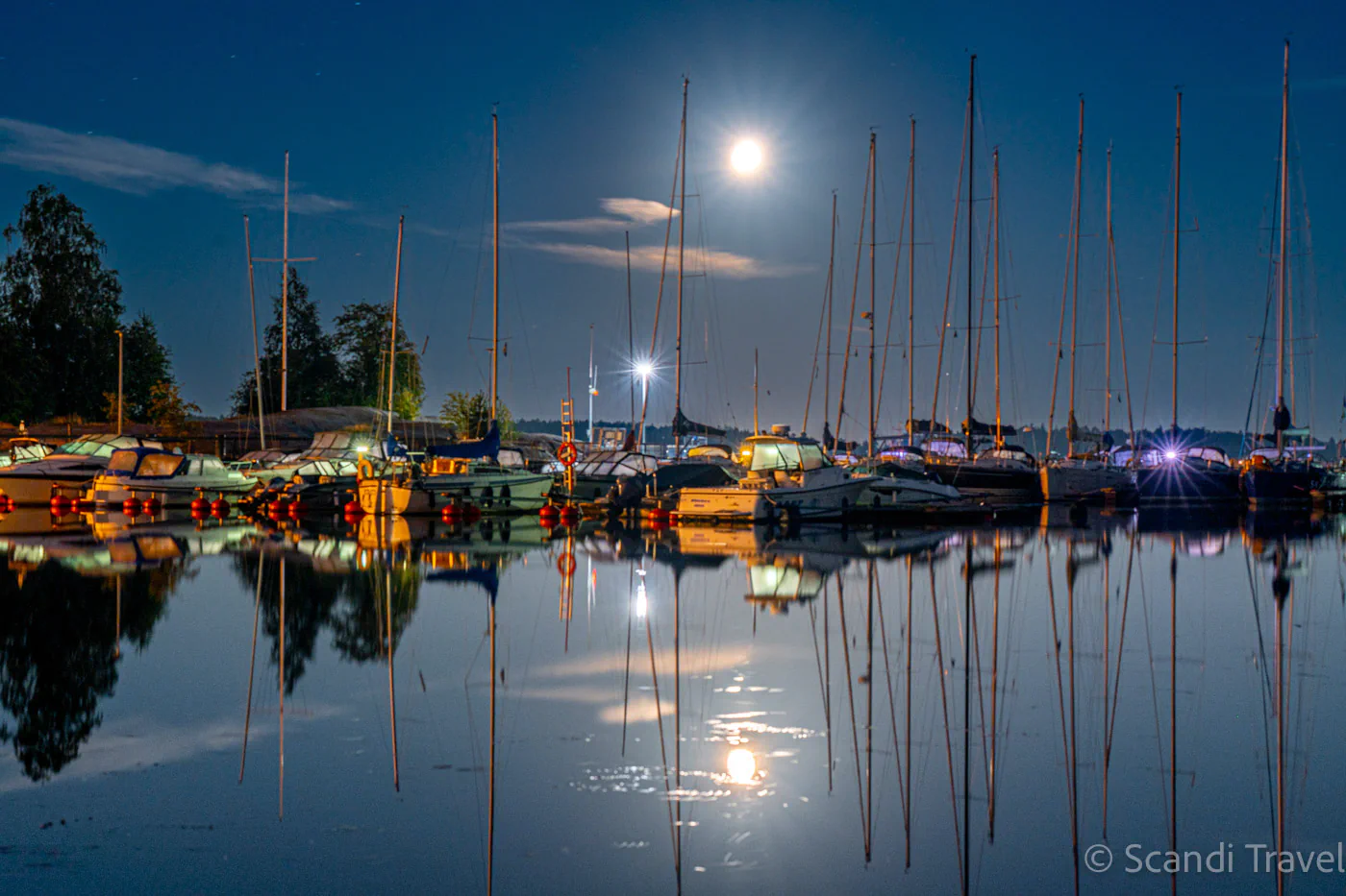 Full moon over Helsinki marina with yachts and reflections in the Baltic Sea