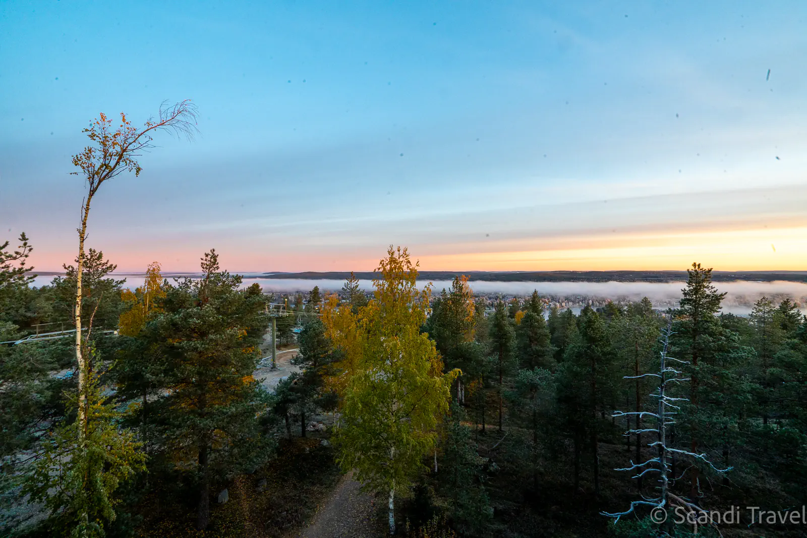Ruska autumn colors over a misty valley seen from the Levi fell chairlift on a Scandi Travel autumn tour
