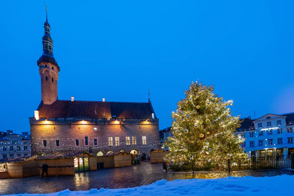 Tallinn Christmas Market 2026 stalls lit up on Raekoja plats in front of the Town Hall