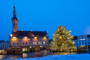 Tallinn Christmas Market 2026 stalls lit up on Raekoja plats in front of the Town Hall