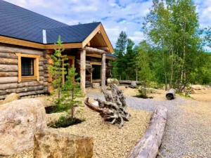 Traditional log cabin exterior in Finnish Lapland surrounded by forest and a landscaped stone garden